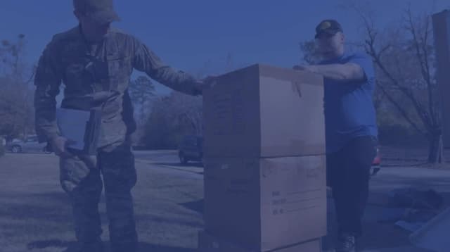 A military member inspects moving boxes during a PCS move.