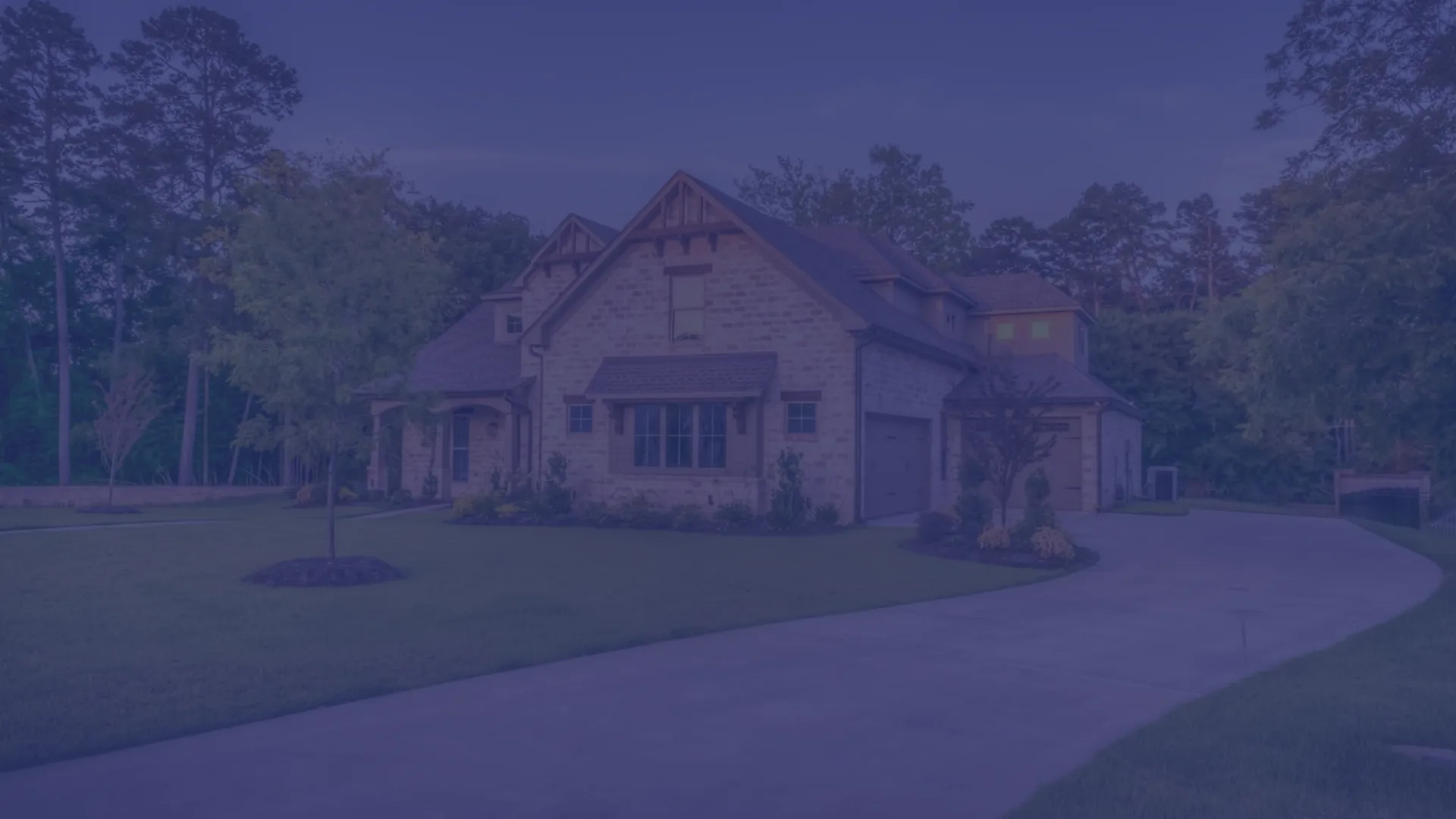 A two-story brick family home in Florida with a curved driveway and landscaped front yard at dusk