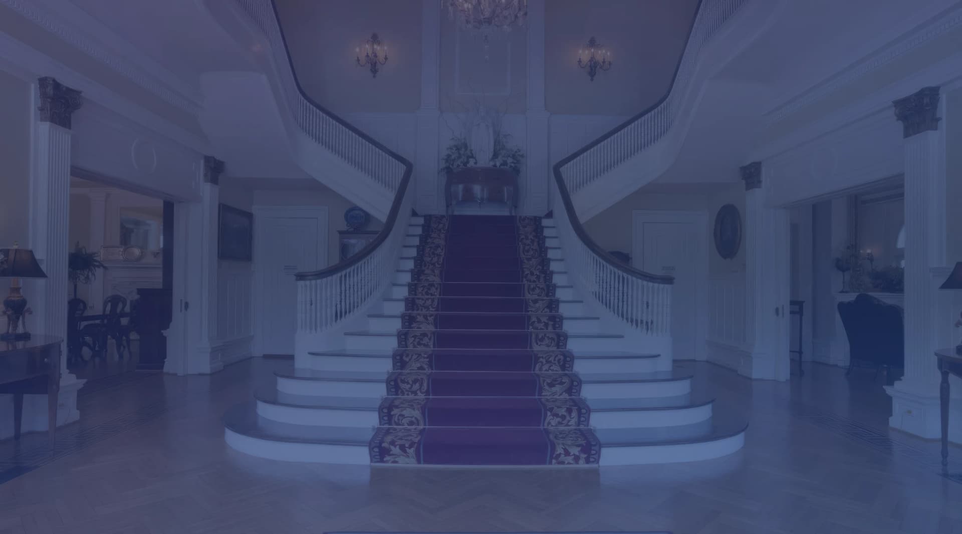 Sweeping double staircase with red carpet runner in the grand foyer of the Alabama Governor Mansion in Montgomery