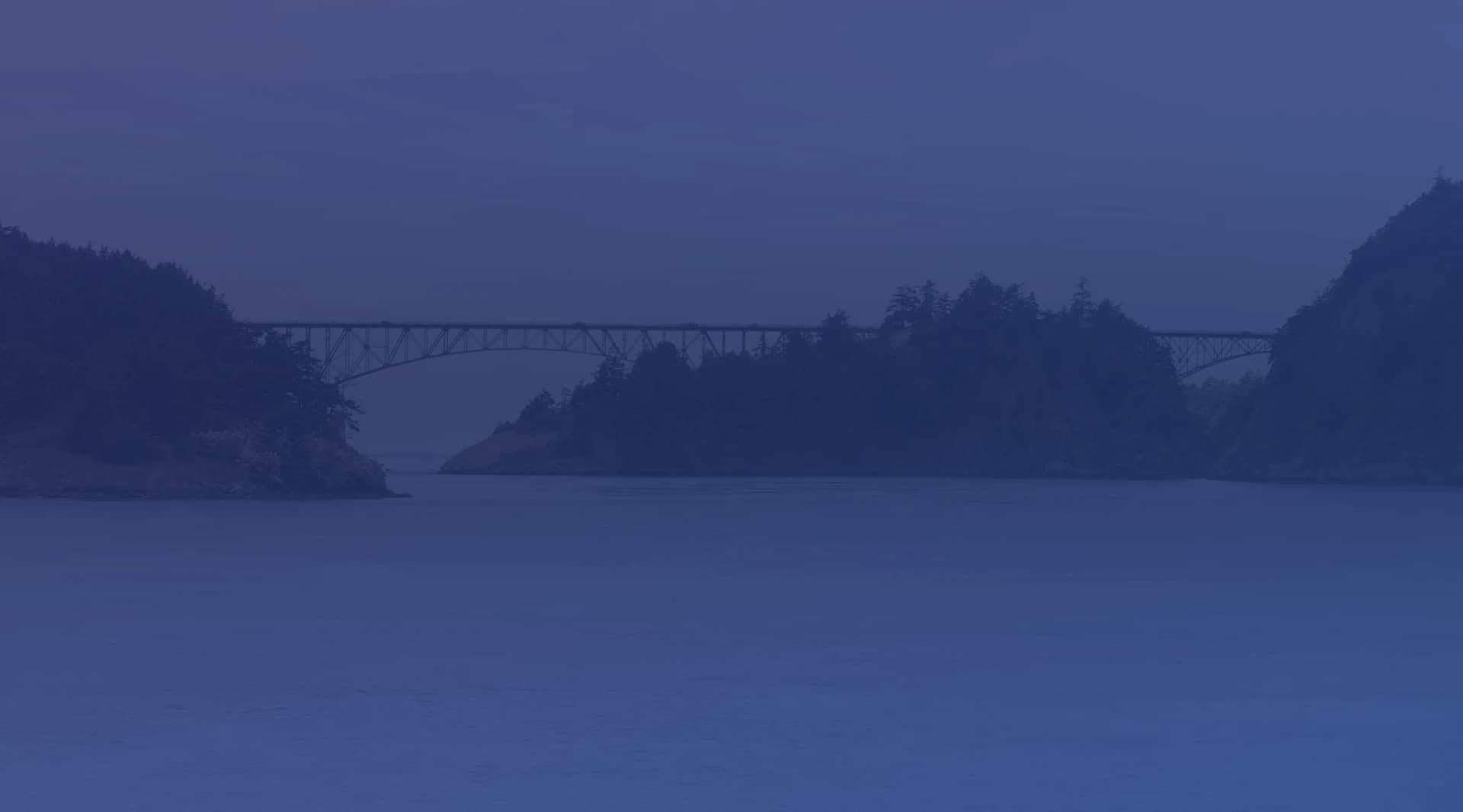 Deception Pass bridge spanning the Salish Sea strait between Whidbey Island and Fidalgo Island, with evergreen forest and blue water below