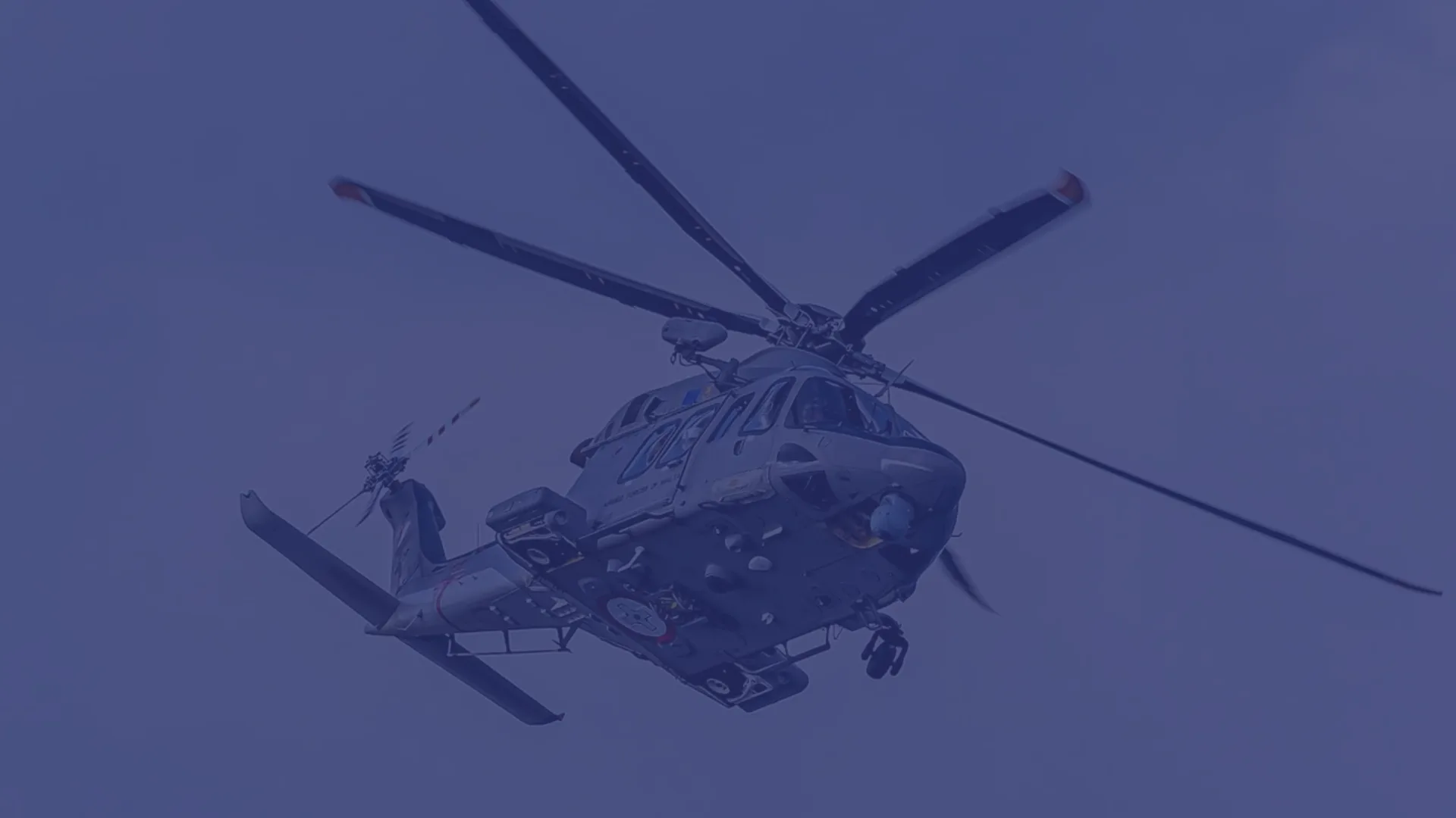 A military helicopter hovering against a deep blue Northwest Florida sky.