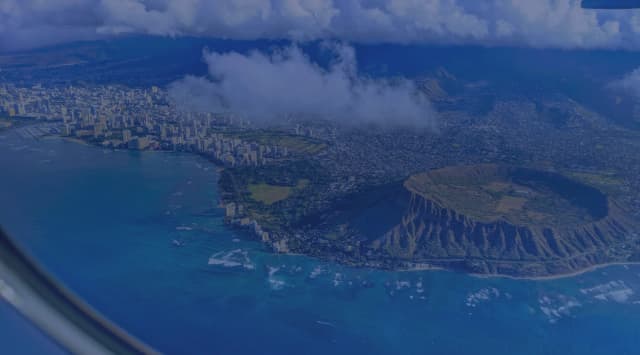 Aerial view of Diamond Head crater, Waikiki and the Honolulu shoreline on Oahu seen from an airplane window