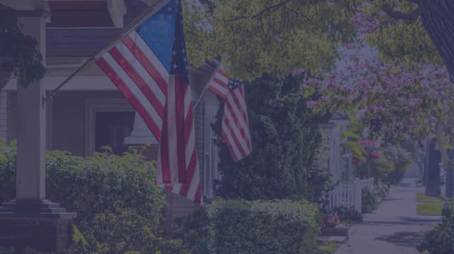 American flags waving in the breeze off a porch.