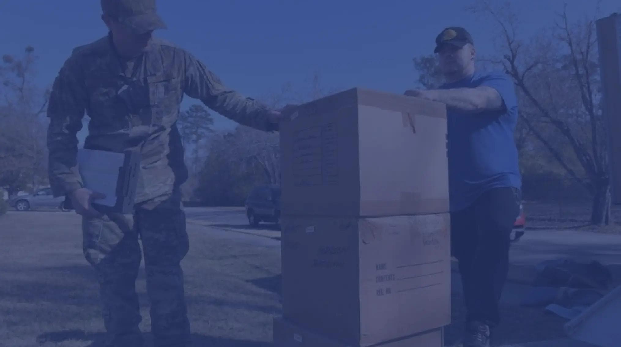 A military member inspects moving boxes during a PCS move.