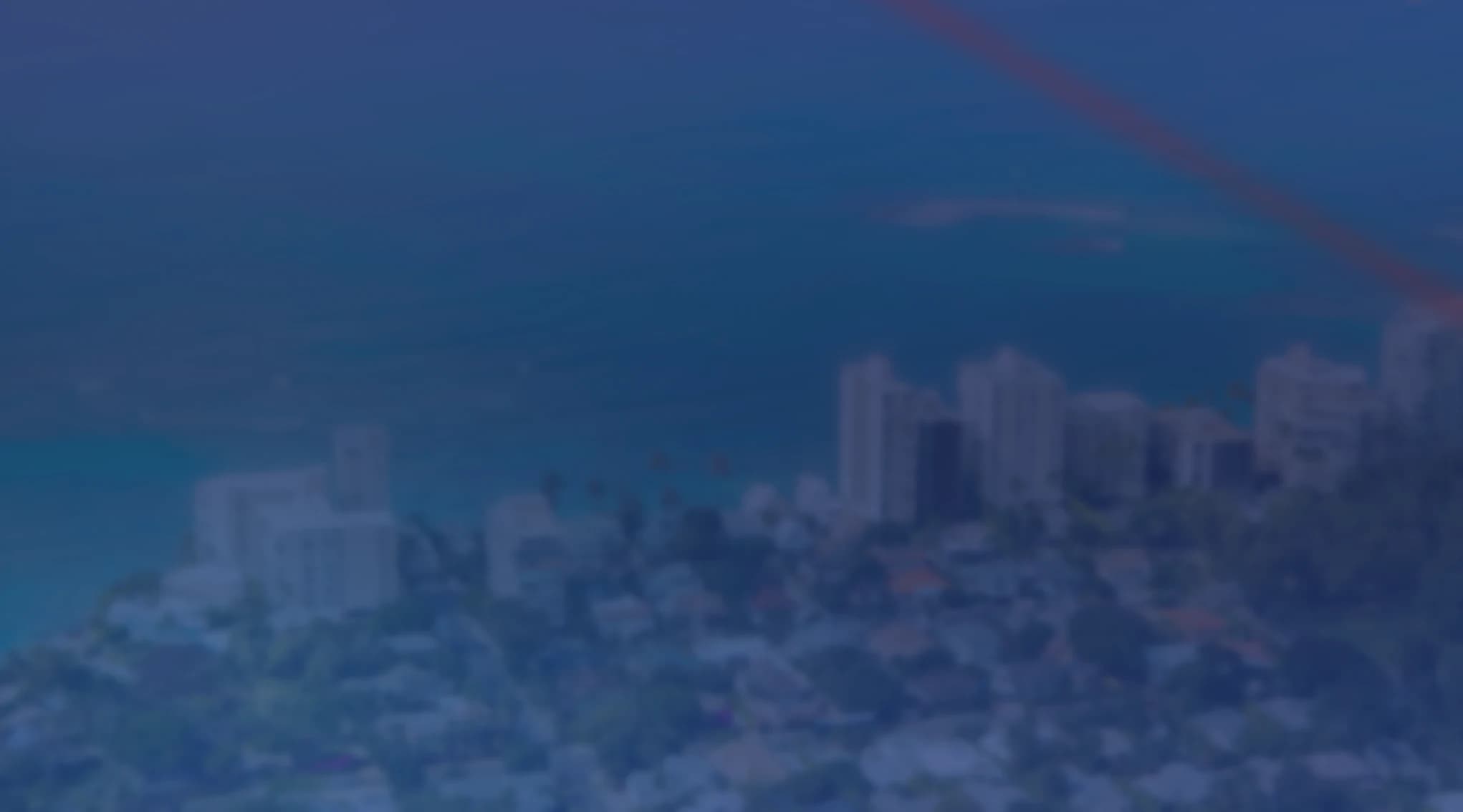 Aerial view of a coastal neighborhood with homes and low-rise buildings along the waterfront