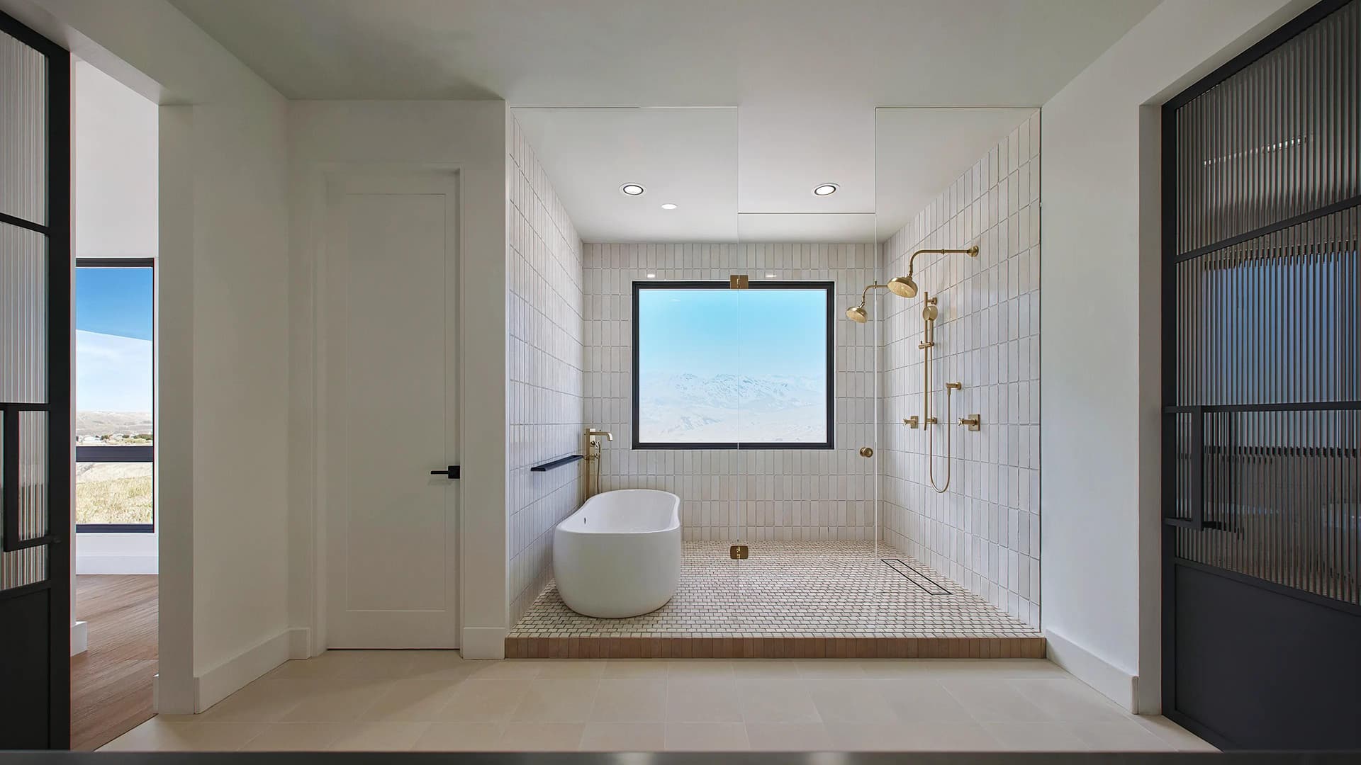 A luxurious full bath with golden shower head and full view of Castle Rock, CO.