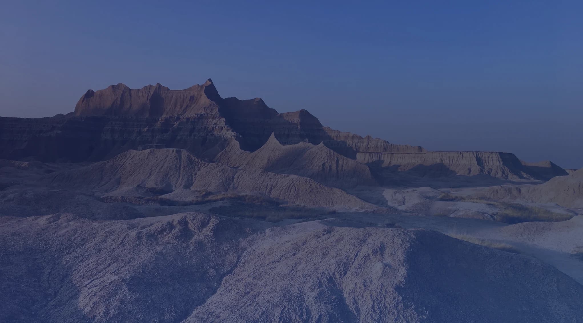 Eroded buttes and layered rock formations of the Badlands at dusk, in western South Dakota near Ellsworth Air Force Base
