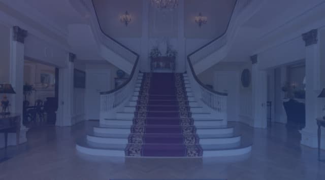 Sweeping double staircase with red carpet runner in the grand foyer of the Alabama Governor Mansion in Montgomery