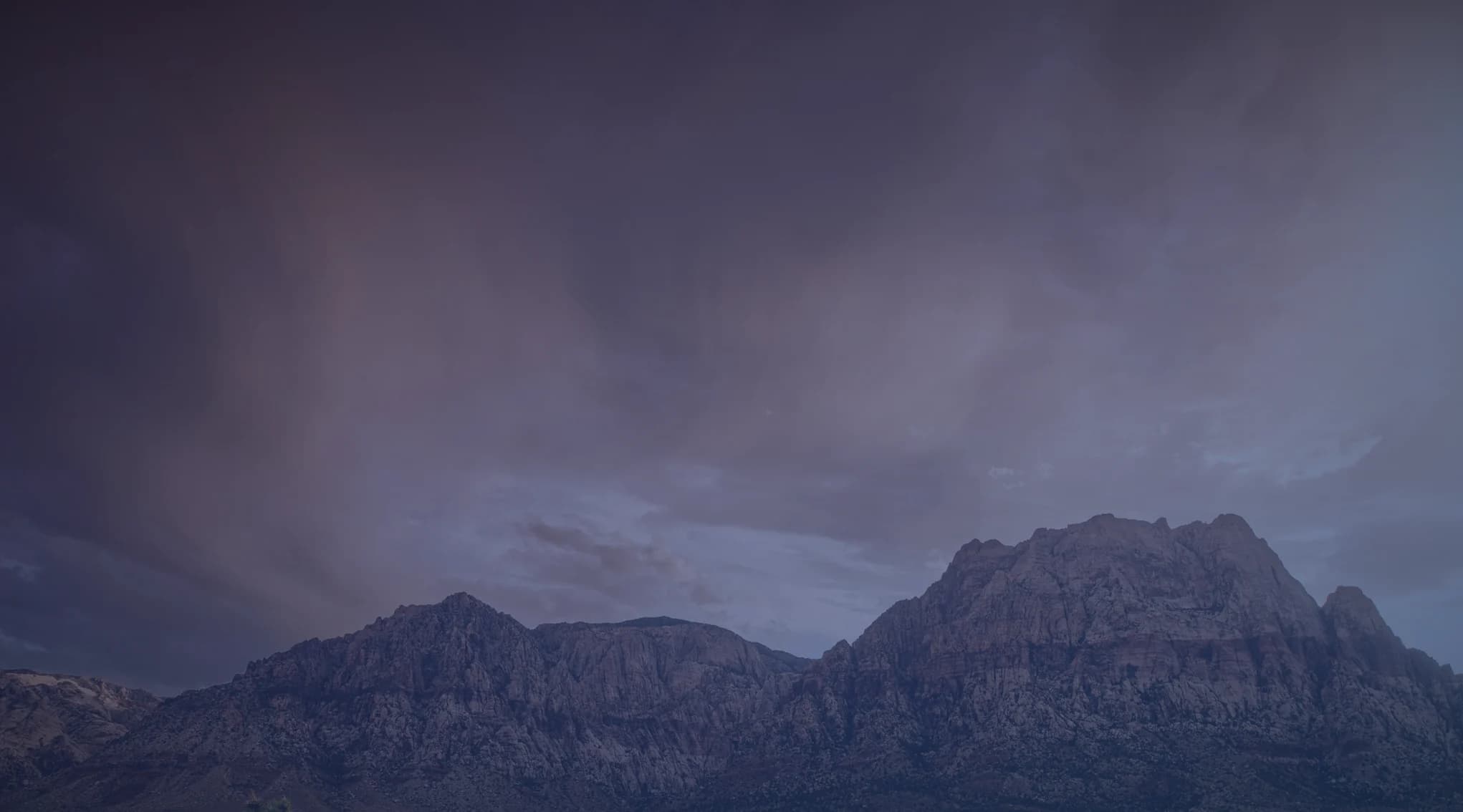 Red rock mountains and desert scrub under a dramatic sky near Las Vegas, Nevada.