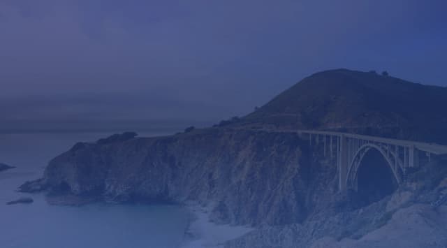 Bixby Creek Bridge arching over the Big Sur coastline with dramatic cliffs and the Pacific Ocean below, near Monterey, California