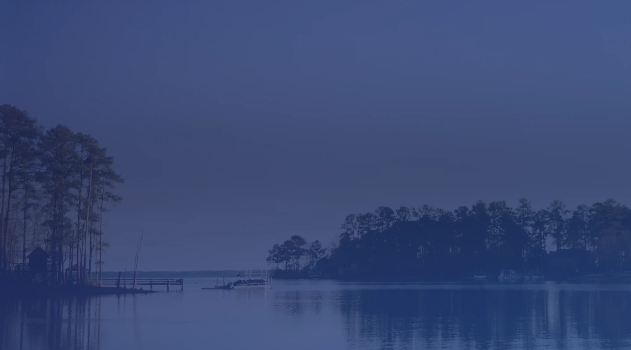 Green trees reflected in a calm South Carolina lake at sunset, typical of the midlands landscape near Sumter and Shaw AFB
