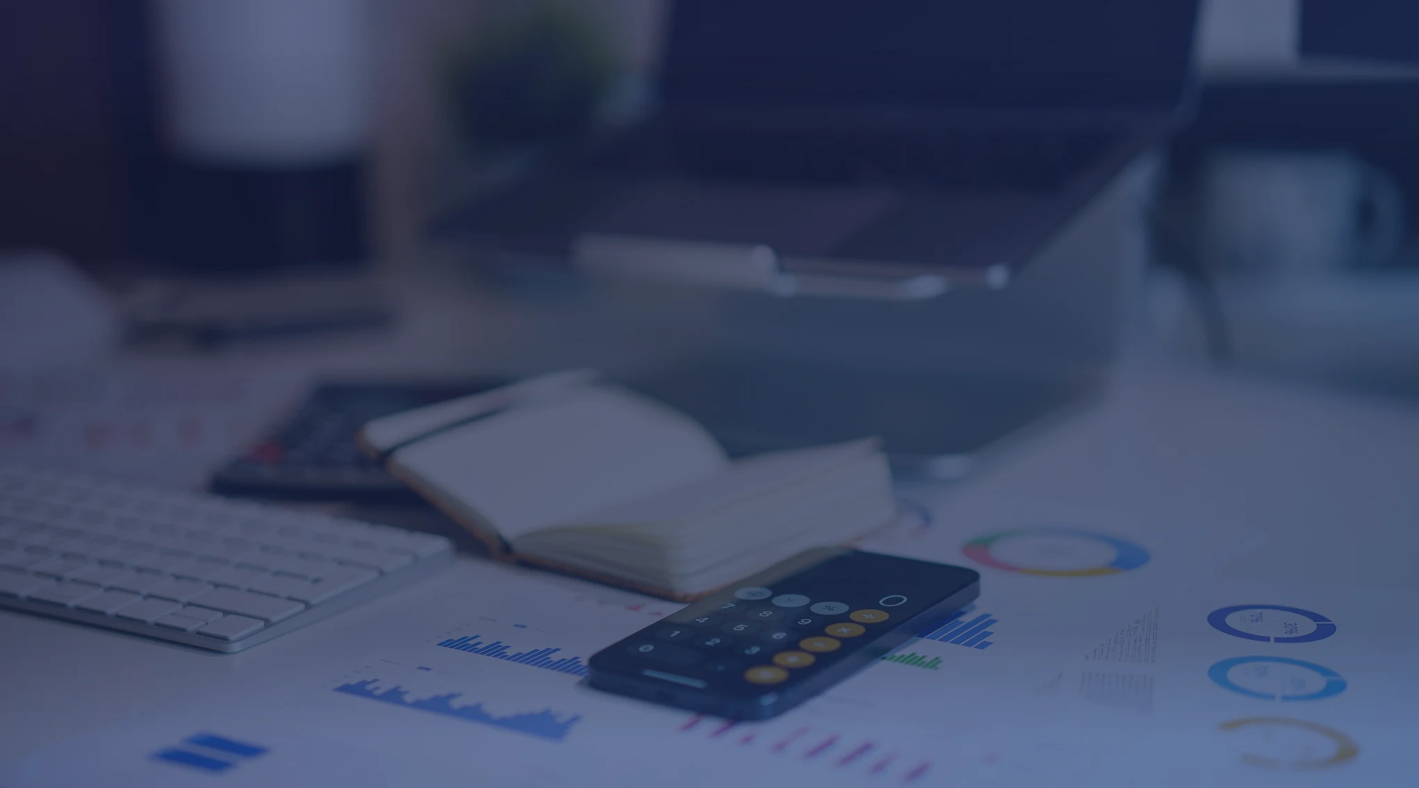 A desk with financial charts and a calculator used for retirement planning